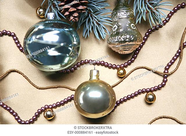 Christmas composition: glassy balls, beads and part of a Christmas twig with fir cone