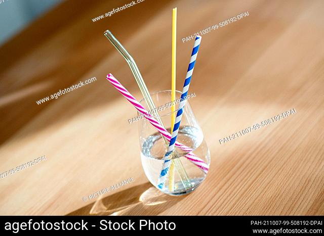 ILLUSTRATION - 01 October 2021, Lower Saxony, Oldenburg: A glass of water with several reusable drinking straws made of hard plastic