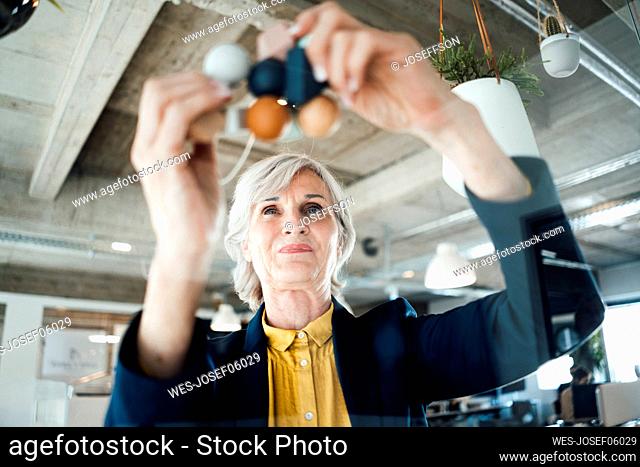 Businesswoman holding molecule in office