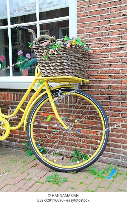 Old yellow bike leaning against a brick wall in Amsterdam, Holland
