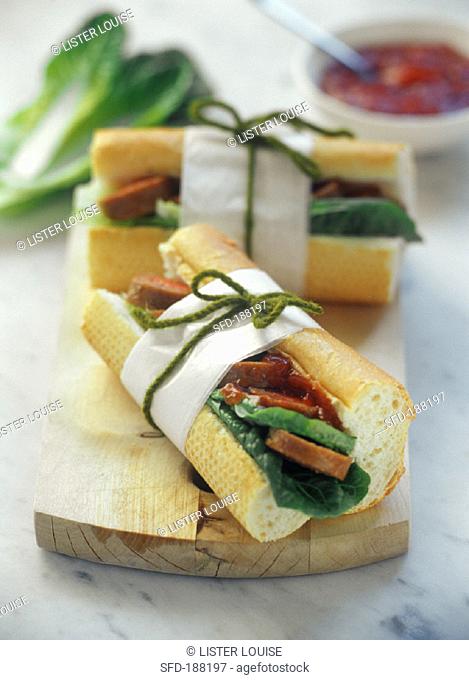 Baguette pieces filled with salad, sausage and ketchup sauce