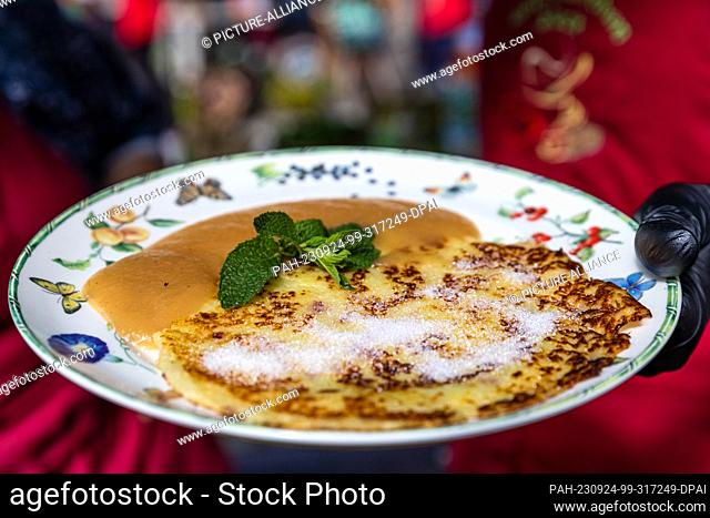 24 September 2023, Brandenburg, Lübbenau/Ot Lehde: A Spreewald potato pancake with applesauce and sugar lies on a plate in the Spreewald village of Lehde