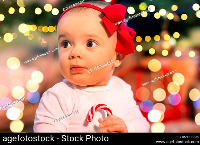 beautiful baby girl over christmas tree lights
