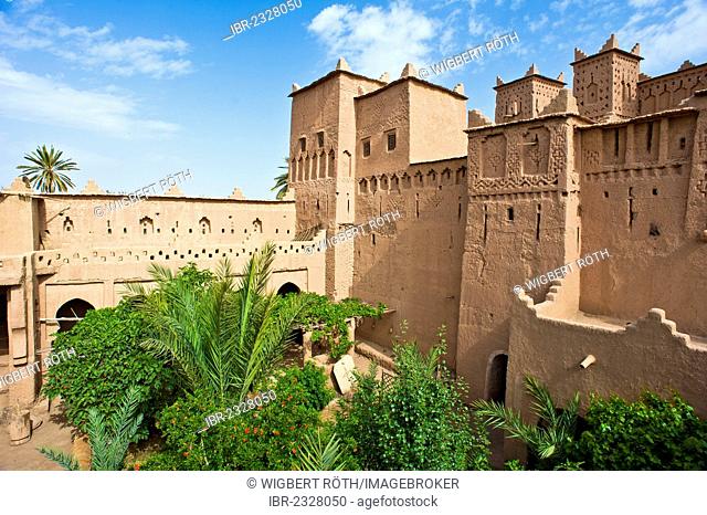 Towers and walls with ornamental decorations and courtyard with trees of a kasbah, mud brick fortress of the Berber people, Tighremt, Amerhidil Kasbah, Skoura