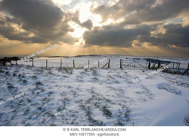 Sun bursting through clouds over a snowy landscape. South Downs - East Sussex - United Kingdom