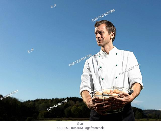 Chef holding basket full of eggs