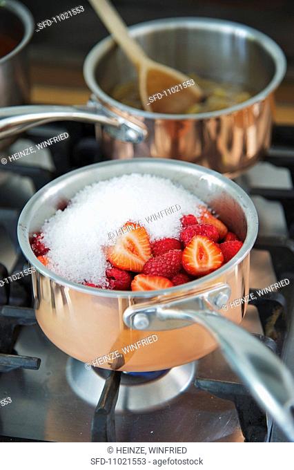 Jam making: A pot of fruit and preserving sugar on a hob