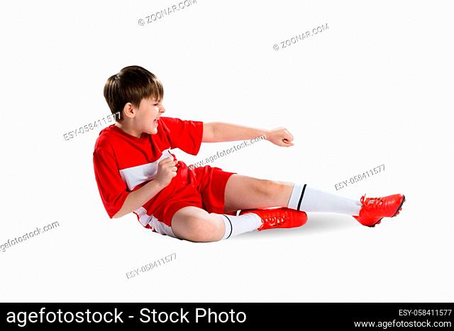 Boy football player in red uniform against white background