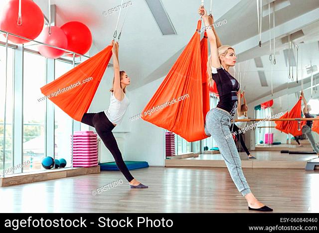 Fly yoga. two women practices anti-gravity yoga with a hammock