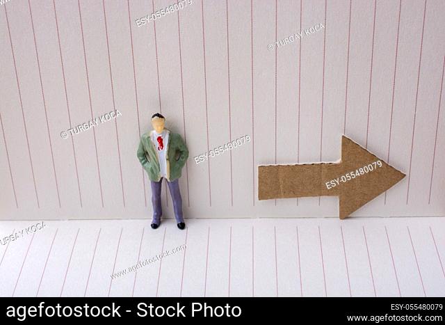 Figurine and an paper arrow in a notebook on canvas