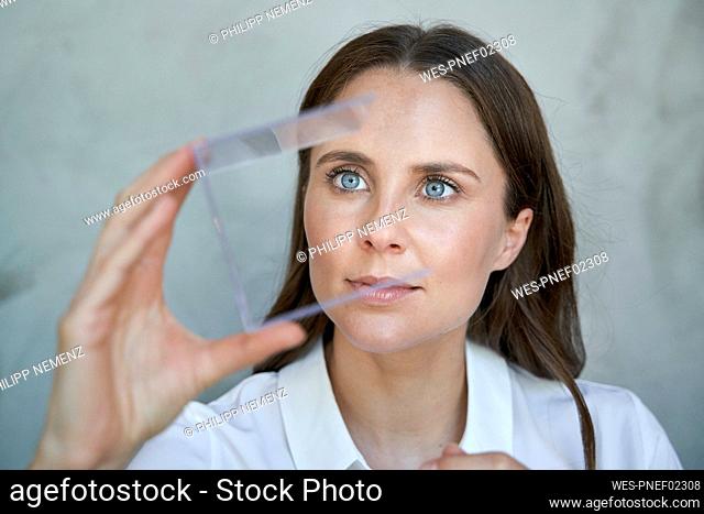 Portrait of woman looking at transparant cube