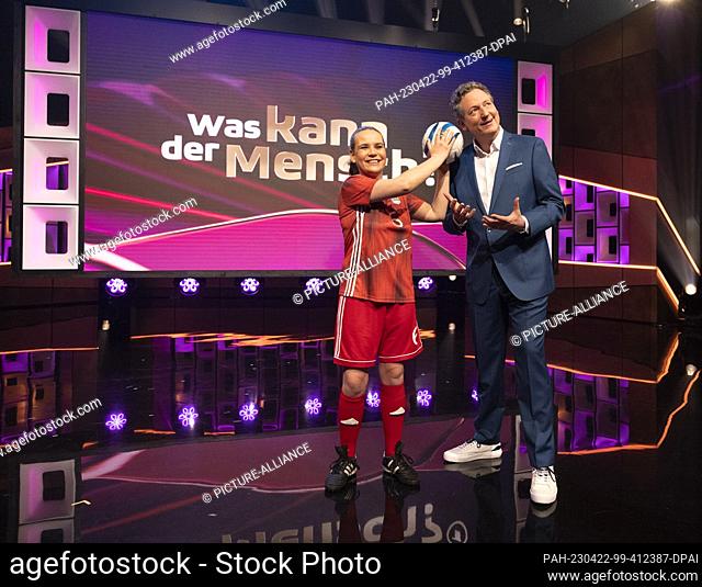 22 April 2023, North Rhine-Westphalia, Cologne: Presenter Eckart von Hirschhausen stands with blind soccer player Jana Marquart in the TV studio before the...