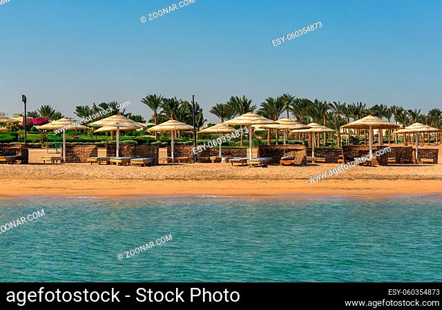 Empty beach with beach loungers and umbrellas. Resort coast without people . Concept of the collapse of the tourism industry