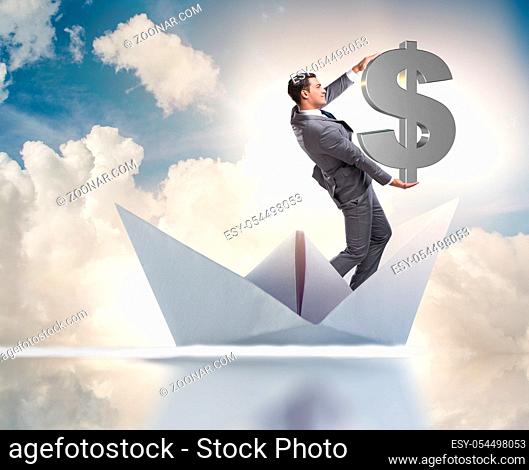 The businessman holding dollar riding paper ship boat