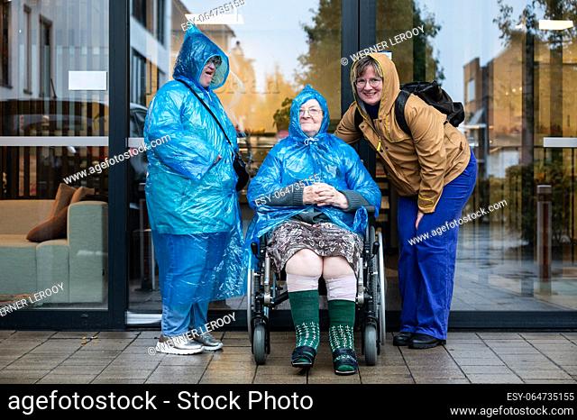 Family portrait of a 41 yo woman with Down Syndrome, a grandmother in a wheelchair and a 37 yo woman wearing rain clothes, Tienen, Belgium