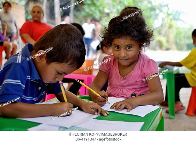 Children drawing at a children's festival, a peace initiative by the police and the Catholic Church in the slum of Colonia Monsenor Romero, Distrito Itália