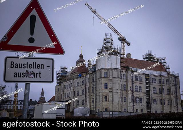 PRODUCTION - 11 December 2023, Mecklenburg-Western Pomerania, Güstrow: The towers, chimneys and roof are currently being extensively renovated and the castle is...