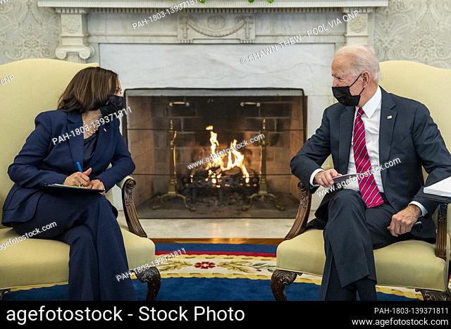 United States President Joe Biden talks with US Vice President Kamala Harris (L) during an economic briefing with Secretary of Treasury Janet Yellen in the Oval...
