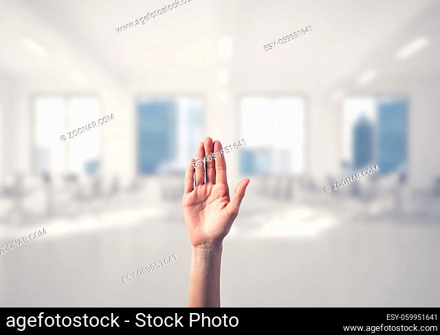Close of woman hand touching screen with palm and office at background