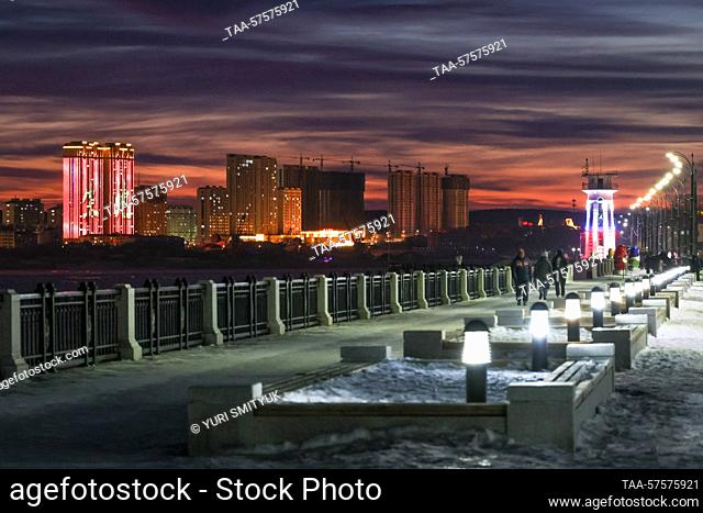 RUSSIA, BLAGOVESHCHENSK - FEBRUARY 25, 2023: A view of the promenade by the Amur River at dusk in winter. Seen in the distance is the Chinese city of Heihe