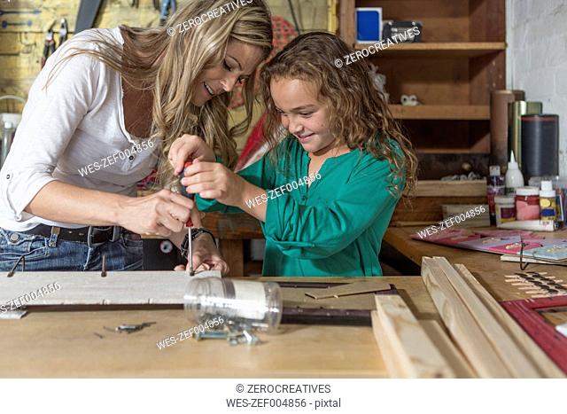Mother and daughter doing crafts in home garage