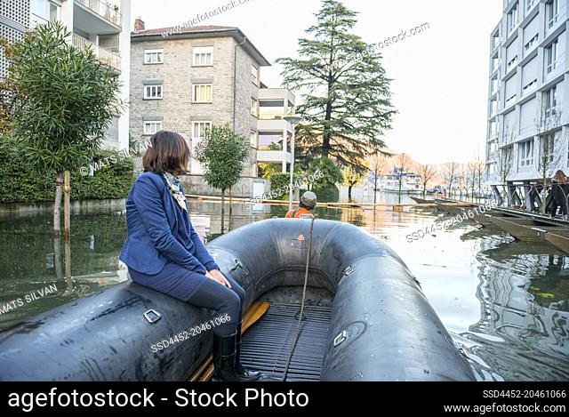 Woman Travel in a Rescue Boat in City of Locarno on Flooding Street in Ticino, Switzerland
