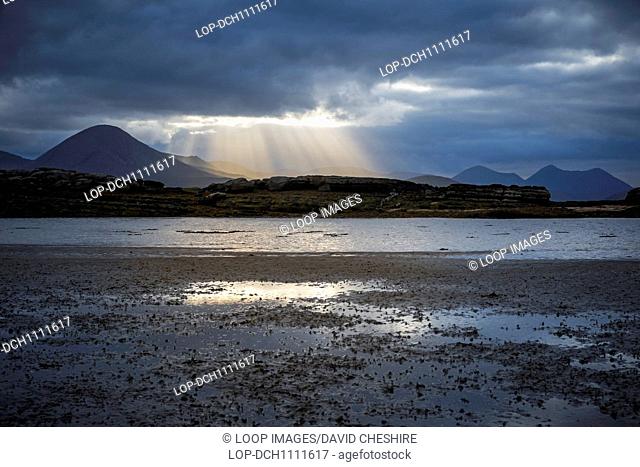 Sunlight breaking through storm clouds on the Isle of Skye