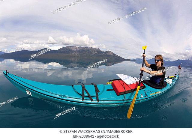 Young woman in a sea kayak, paddling, sea kayaking, mountains behind, Tagish Highland, Atlin Lake, British Columbia, Canada, America