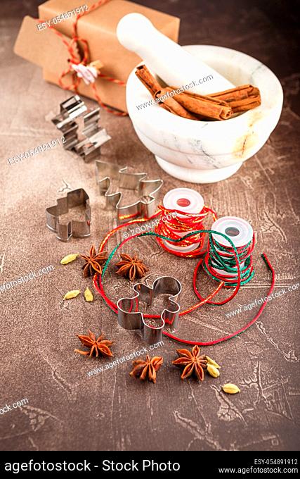 Ingredients for Christmas cookies - spices, cinnamon, anise stars and cardamom, marble mortar and cookie cutters