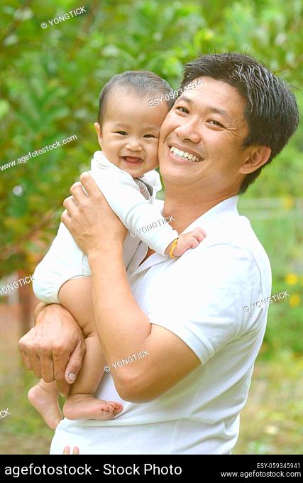 Happy father's day! joyful young dad hugging his cute son at outdoor park