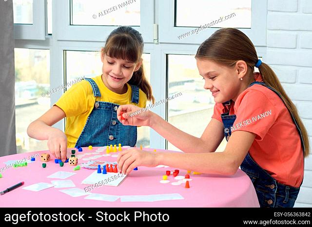Two happy girls spend home leisure playing games