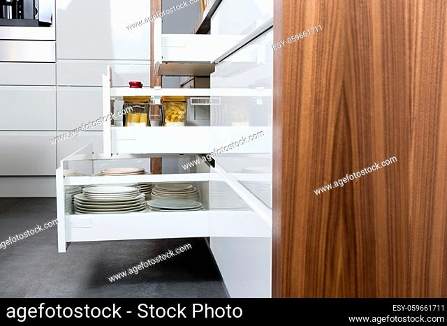 Side view of a spices and groceries organized in a modern kitchen drawer. Kitchen design inspiration