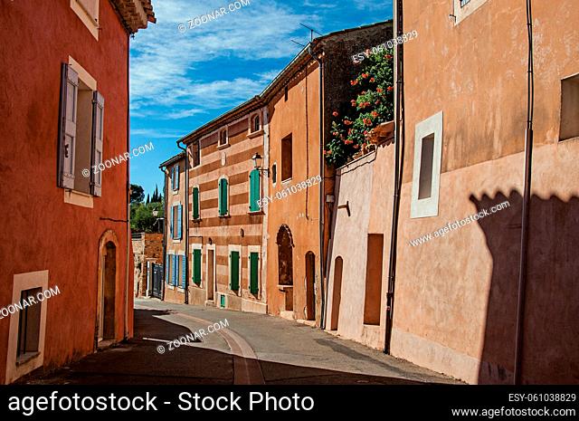 View of traditional colorful houses in ocher and street in the city center of the village of Roussillon. Located in the Vaucluse department, Provence region