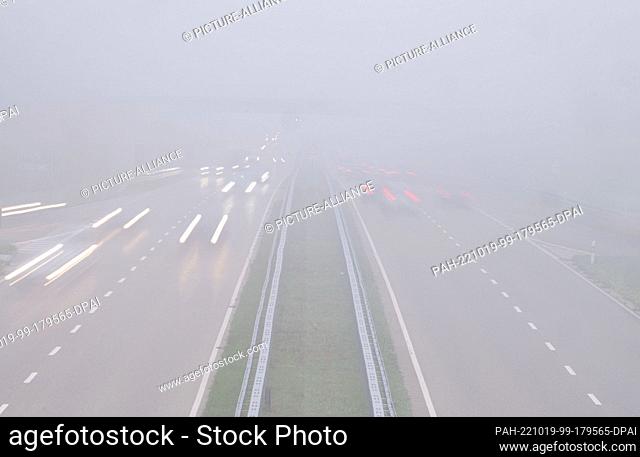 19 October 2022, Baden-Württemberg, Stuttgart: Cars driving on the L1180 in the fog (long exposure). After a foggy morning