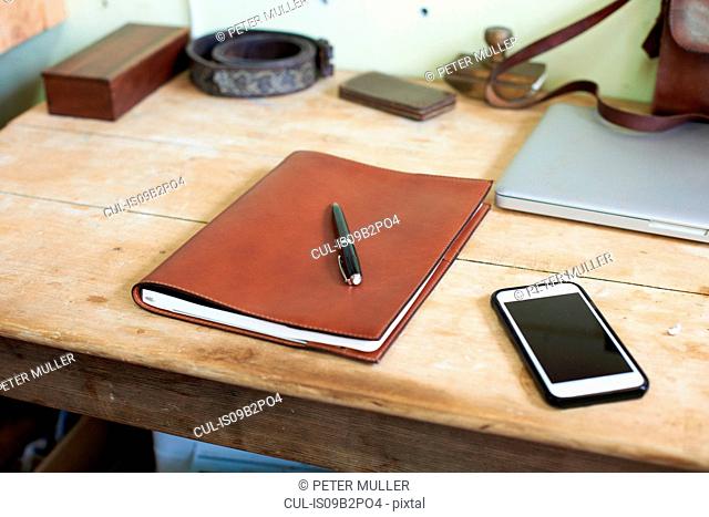 Leather bound book on table in leather workshop