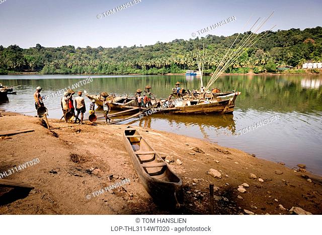 India, Goa, Village Panchayat. Manually offloading sand from a boat on the Mandovi River in Goa
