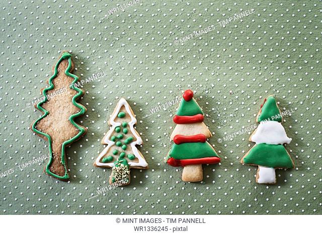 Organic homemade Christmas cookies shaped like Christmas trees, iced with green, red and white icing