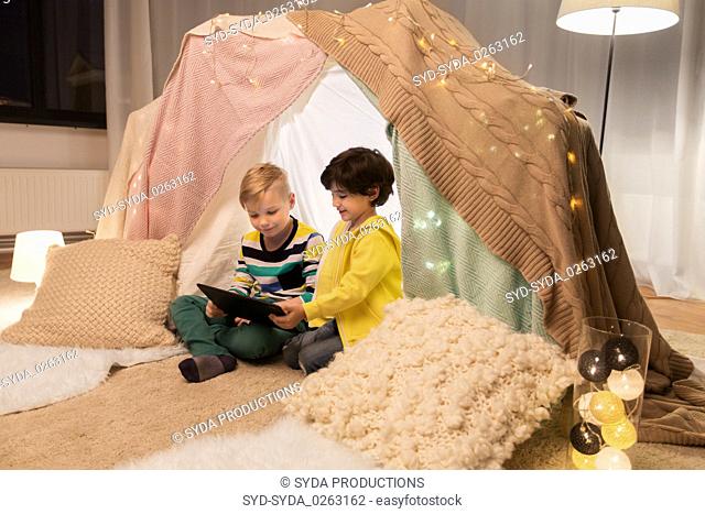 little boys with tablet pc in kids tent at home