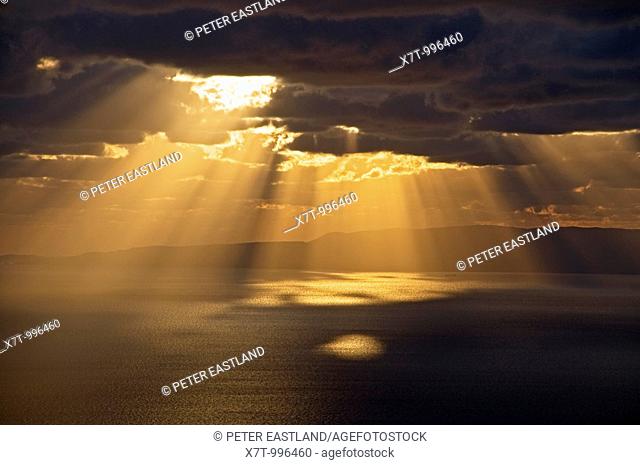 Sun bursting through clouds on the gulf of Messinia near Langada in the Outer Mani, southern Peloponnese, Greece