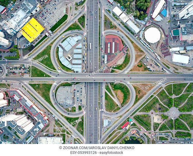 Aerial view city of Kiev, a modern road junction with cars, high-rise buildings, shopping centers with parking lots and green areas, Poznyaki district, Ukraine