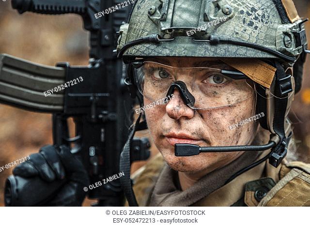 Norwegian Armed Forces Special Command FSK female soldier closeup portrait. Protective eye-wear and assault gun