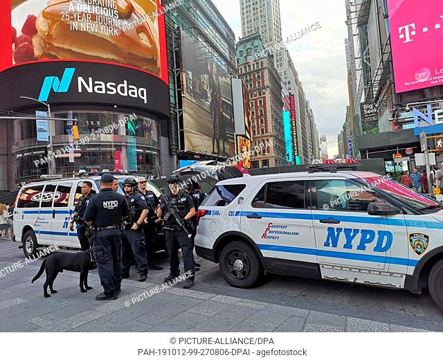08 September 2019, US, New York: Armed police officers of the New York Police Department (NYPD) stand in front of their cars in Times Square