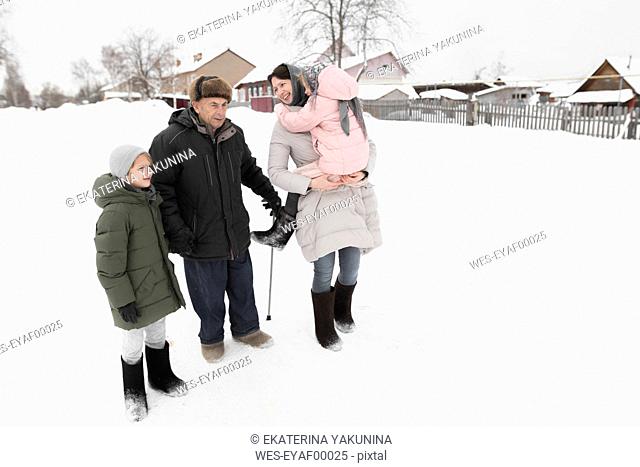 Grandfather together with daughter and grandchildren in snow
