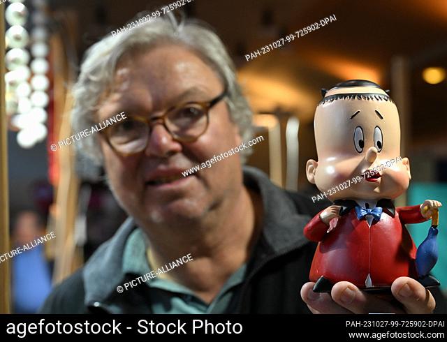27 October 2023, Berlin: Dealer Dirk Baumgarten from Auerswalde near Chemnitz stands at his sales booth at the Ostpro Berlin 2023 trade fair and shows the...