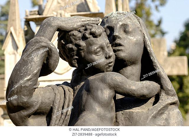 detail of mother and child bronze sculpture at large monumental Cemetery in town, shot in bright late winter light in Milan, Lombardy, Italy