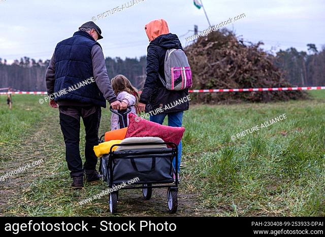 08 April 2023, Brandenburg, Cottbus: A family comes with a handcart to the Branitz Easter fire, which has not yet been lit