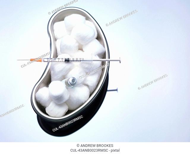 Cotton balls and syringe in kidney bowl