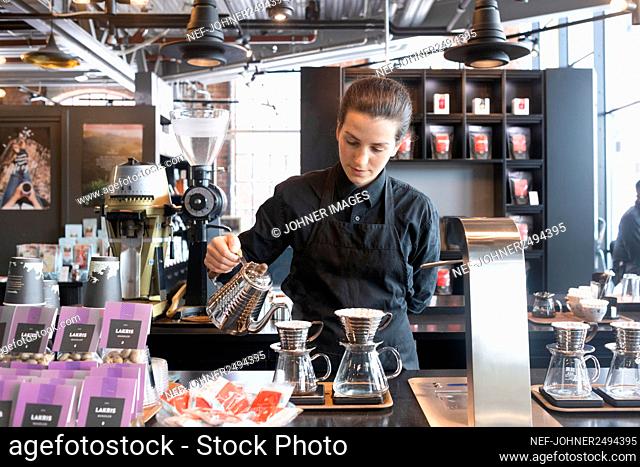 Female barista preparing coffee at counter