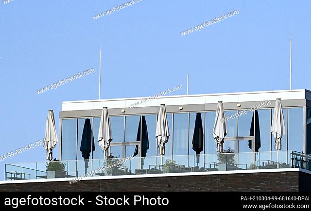 03 March 2021, Berlin: Collapsed umbrellas are seen on the outdoor patio of a rooftop bar. The bar is closed due to the risk of contagion in the COVID-19...