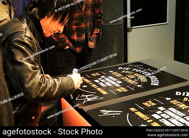 23 February 2023, North Rhine-Westphalia, Duesseldorf: Stephen George Ritchie (Vom Ritchie), drummer of the Toten Hosen, signs a poster at the World Club Dome